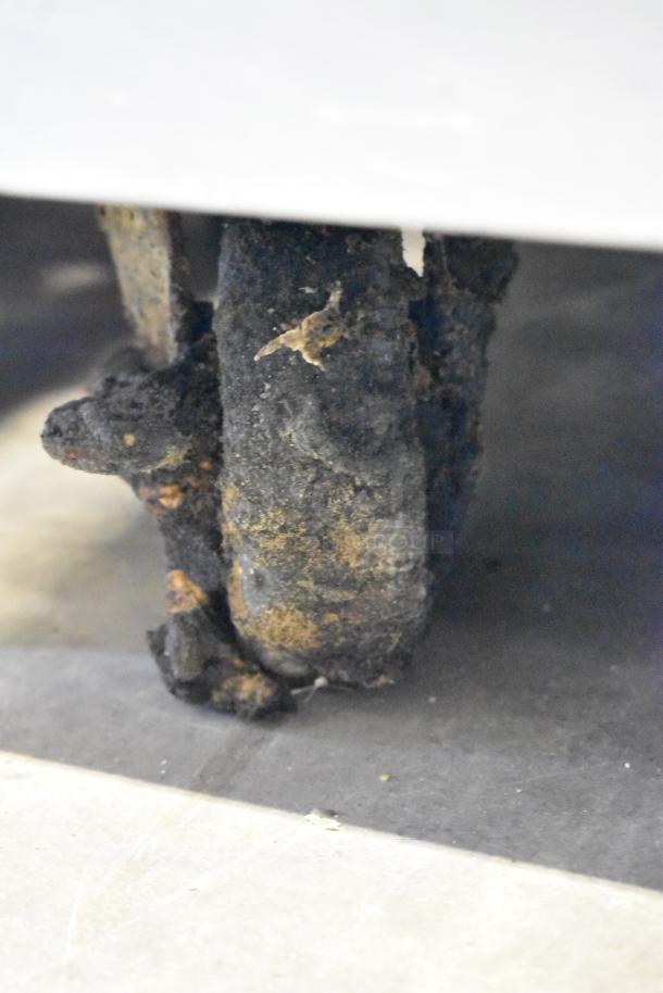 Corroded caster on True TRCB-110 stainless steel chef base, showing significant rust and wear.