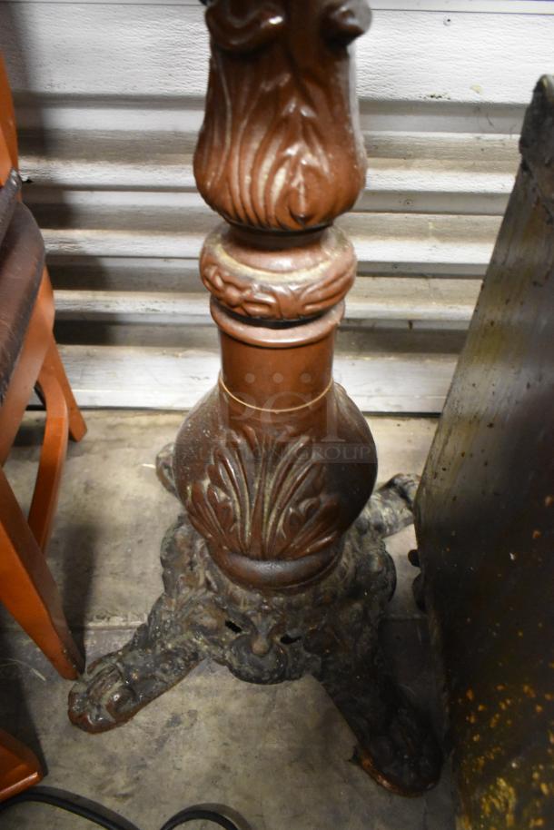 Wooden bar height table with intricately carved round pedestal base, showing signs of wear. Detailed leaf motif design.
