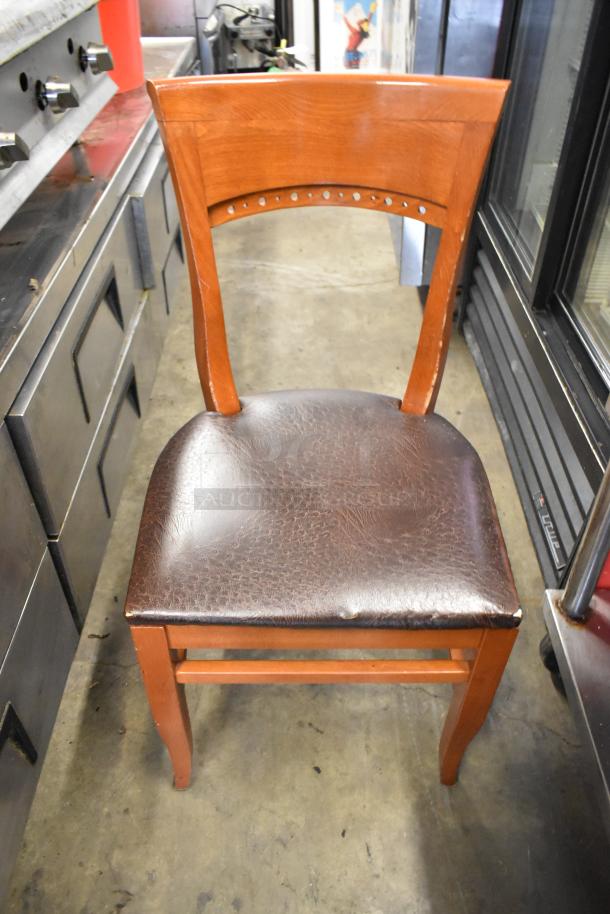 Wooden dining chair with brown seat cushion, solid frame, minimal wear, subtle backrest design, auction lot of 50.