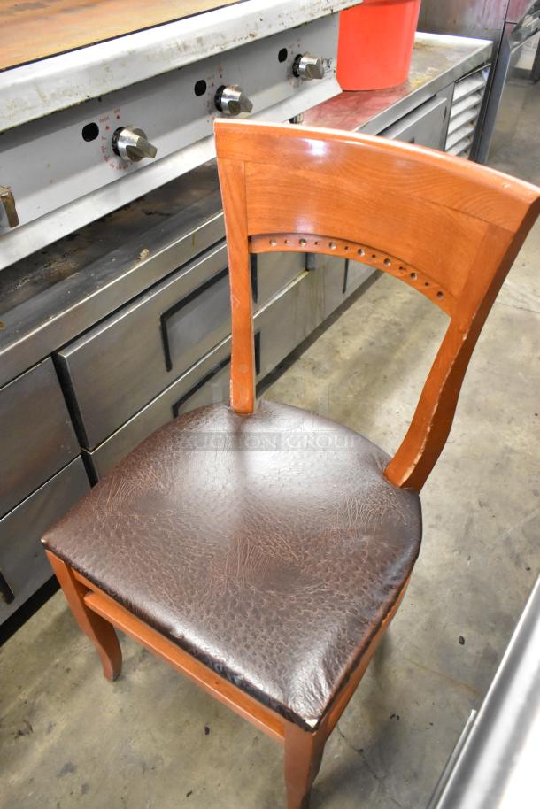 Wooden dining chair with brown seat cushion, slightly worn. Features curved backrest with rivet detail. 50 chairs available.