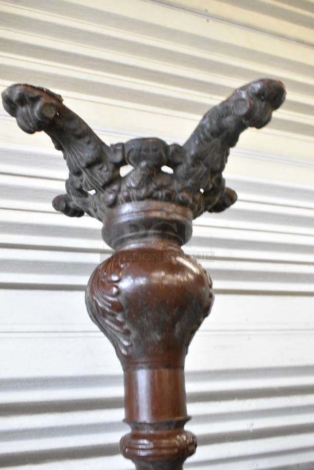Antique wooden table legs with intricate carved details; round tabletop mention in description. Some wear visible.