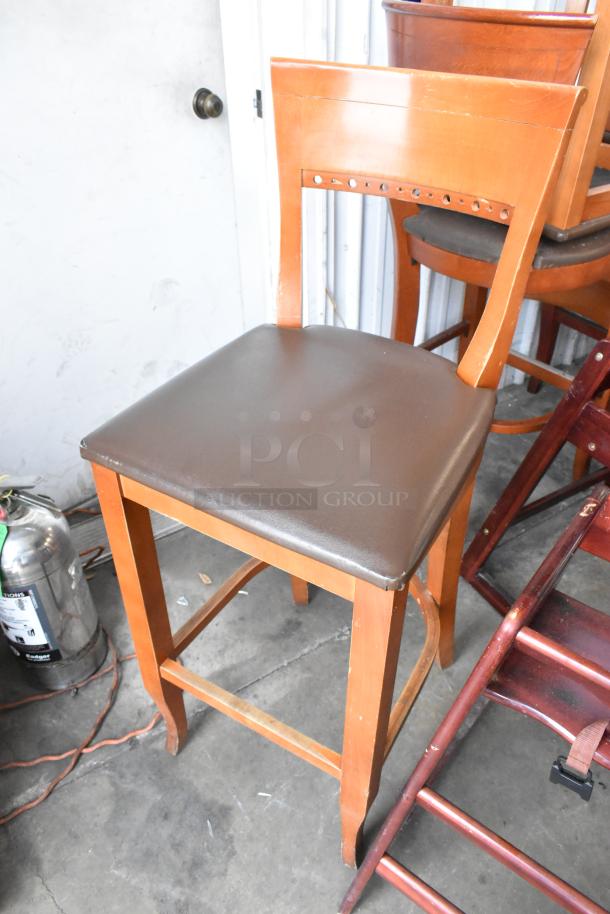 18 wooden bar height chairs with brown seat cushions and 2 wooden high chairs. Good condition. Auction lot of 20 items.