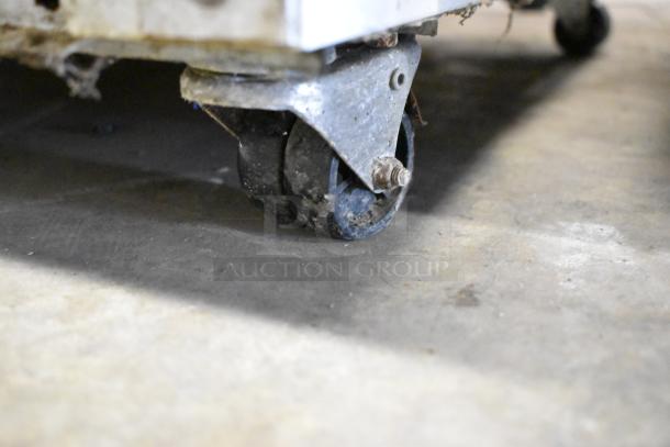 Close-up of a worn caster wheel on a Galaxy 177GRI20FW Single Door Reach In Freezer.