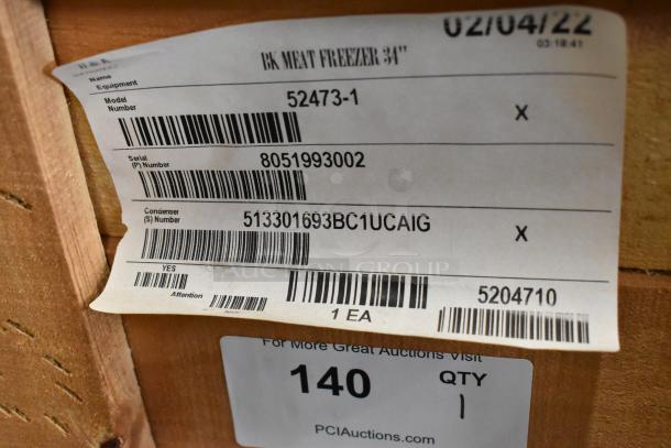 Alt text: "2022 BKI 52473-1 stainless steel commercial meat freezer label with model and serial numbers in crate."