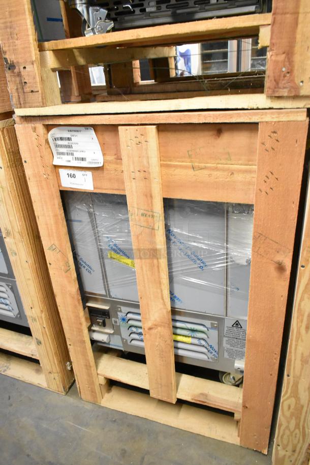 Brand new BKI 52473-1 stainless steel commercial meat freezer, 2021 model, in crate on casters, 115V, 1 phase, labels visible.