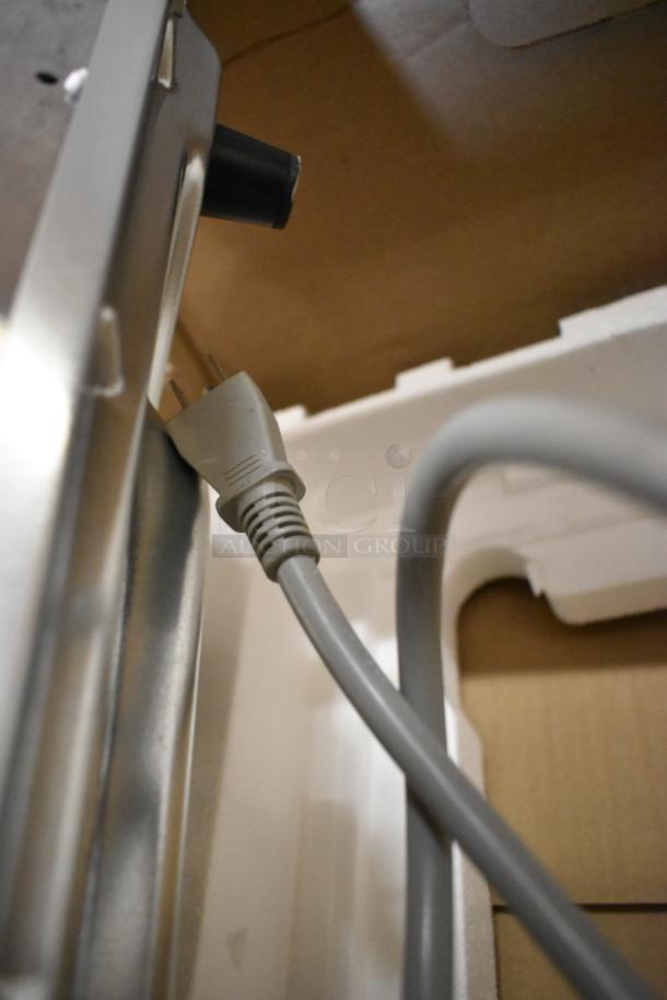 Brand new Amana RMS10DSA commercial microwave plug, shown in packaging. Stainless steel finish, dial controls.