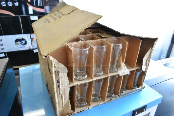 Box of 16 Libbey 6 oz pilsner glasses, brand new, in damaged packaging. Glasses intact, clear, and ready for use.