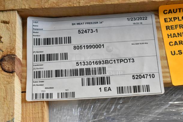 Alt text: 2022 BKI 52473-1 stainless steel commercial meat freezer in crate with label indicating model and serial numbers.