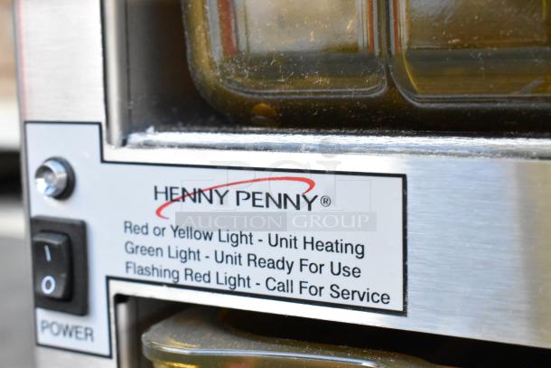 Henny Penny stainless steel holding bin with control panel and indicator lights, brand and operational details shown.