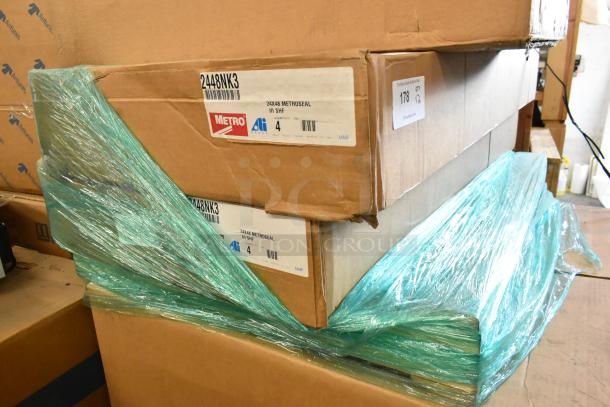 Brand new boxes of 4 Metro 2448NK3 green epoxy coated wire shelves, 48"W x 24"D, with visible tags and labels.