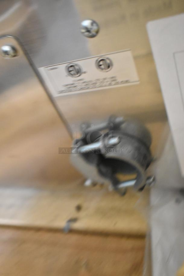 Blurry close-up of a label and metal fittings on the Southbend PE36N-TTT electric griddle.