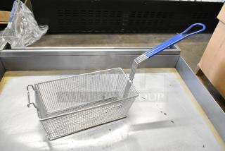 Brand new metal fry basket with blue plastic handle, rectangular mesh design, and durable construction, unused condition.