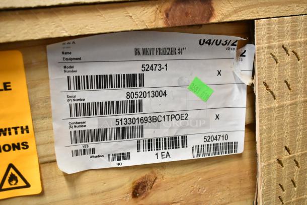 Brand new BKI 52473-1 stainless steel commercial meat freezer, in crate, with label showing model and serial numbers.