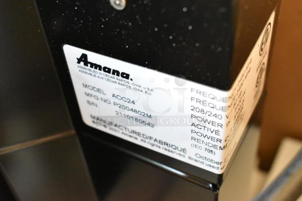 BRAND NEW 2021 Amana AOC24 stainless steel commercial microwave with touch pad, 208-240 volts, model and serial labels shown.