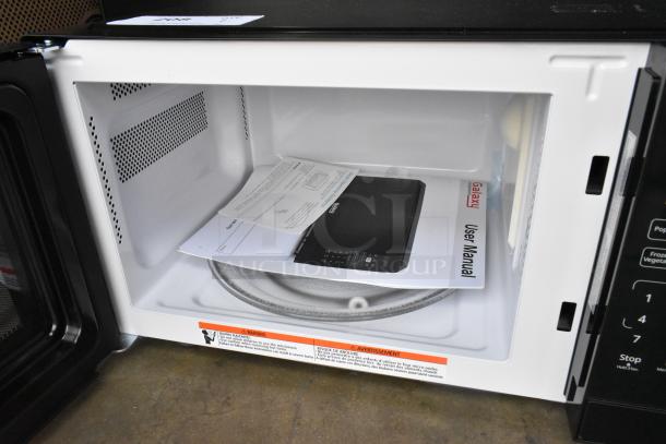 Brand new Galaxy 177MW900D0A microwave, visible interior, user manual, push button controls, 120V, scratch and dent condition.