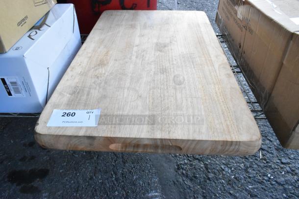 Brand new scratch and dent wooden cutting board with natural wood grain, handle cutouts, and minor surface imperfections.