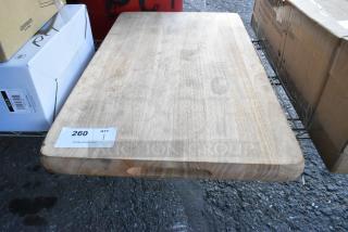 Brand new scratch and dent wooden cutting board with natural wood grain, handle cutouts, and minor surface imperfections.