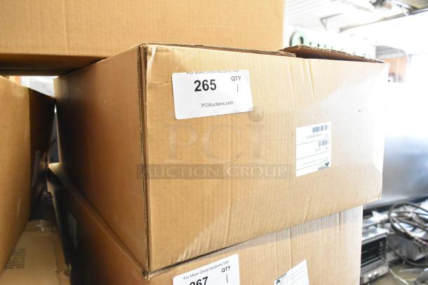 Brown shipping box labeled "PCI Auctions" containing a Prince Castle 464-B stainless steel 13-inch single chamber front loader toaster. Box shows slight wear.