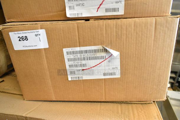 Box containing Prince Castle 464-B stainless steel 13" toaster, single chamber, front loader. Scratch and dent condition. Barcodes and label visible.