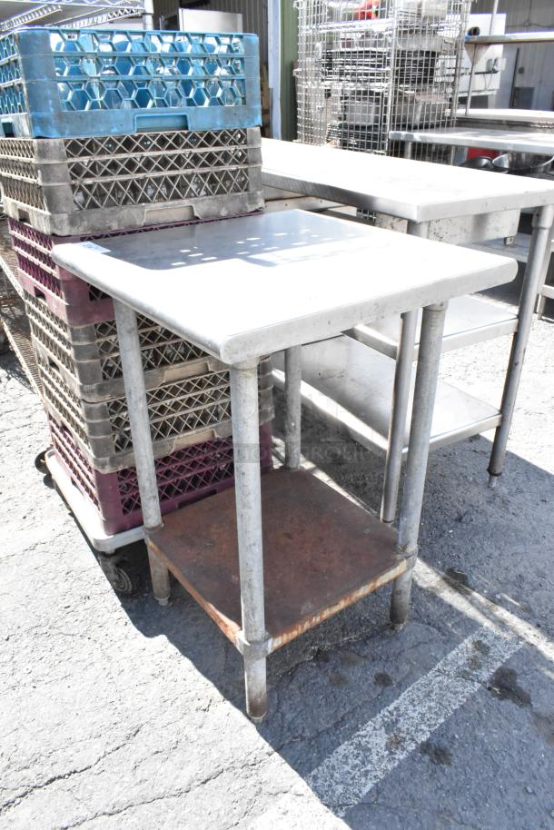 Stainless steel table with metal undershelf, showing visible wear. Ideal for industrial or kitchen use.