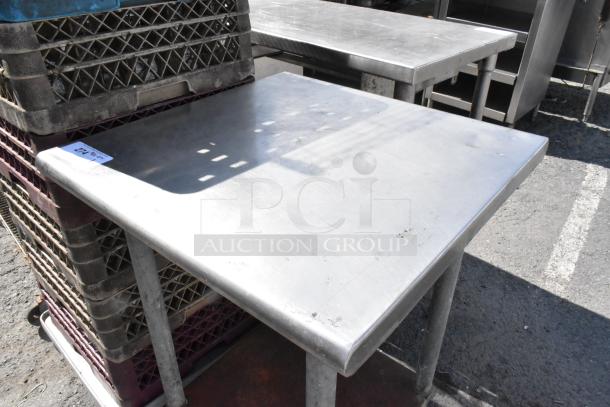 Stainless steel table with metal under shelf, visible minor surface scratches, auction tag "214" attached.