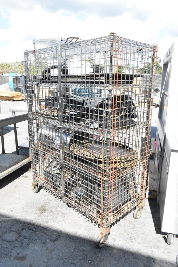 Chrome 5-tier wire shelving unit with liquor cage on casters, includes contents. Dismantling required by buyer. Freight charges apply.