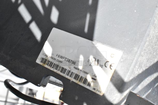 Label on Chrome 5 Tier Wire Shelving Unit with liquor cage and contents, model F6WF038790 by Seiko Epson Corp.