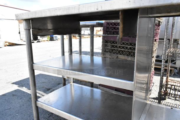 Stainless steel table with metal under shelf, showing a durable construction and spacious storage, good condition.
