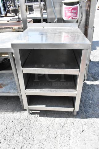 Stainless steel table with under shelves, durable condition, 3-tier design, suitable for kitchen or industrial use.