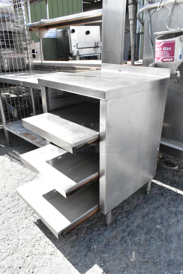 Stainless steel table with under shelves, multiple pull-out trays, used condition, ideal for kitchen storage solutions.
