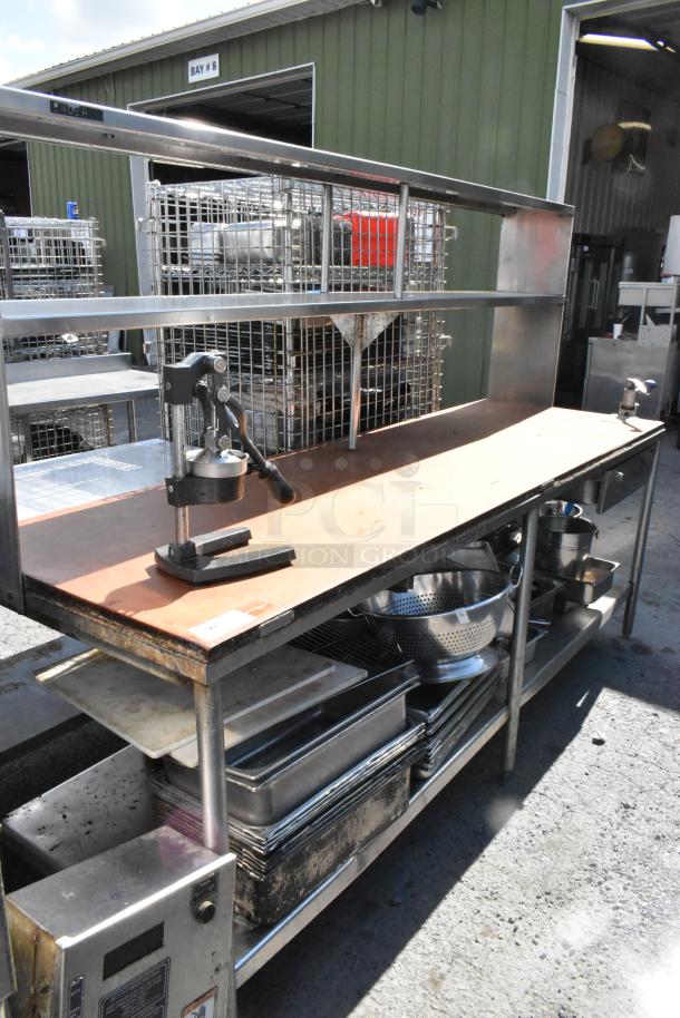 Stainless steel table with commercial can opener, 2-tier overshelf, undershelf, and stainless drop-in bins; used condition.