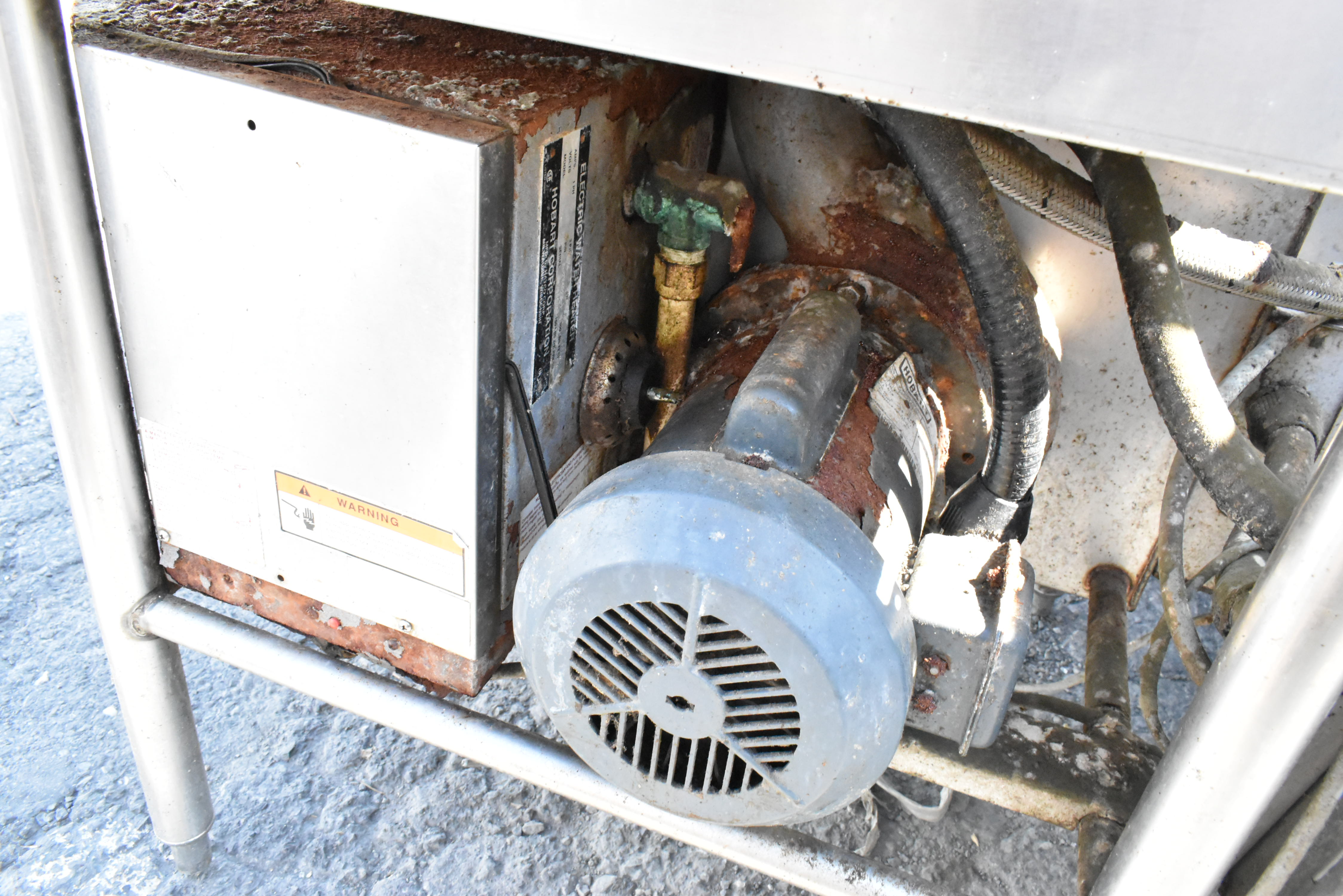Commercial dishwasher showing hard water deposits, corrosion, and rust buildup as warning signs