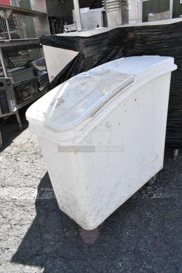 White poly ingredient bin with lid on commercial casters, showing signs of use. Ideal for kitchen storage.
