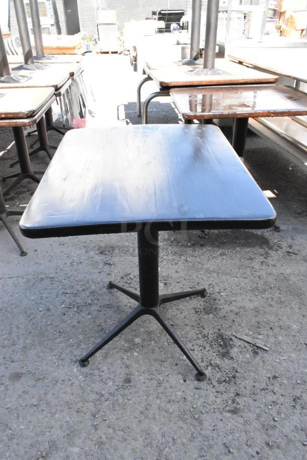 Set of 6 dining height tables, black square tops, sturdy metal bases, used condition, ideal for indoor or outdoor use.