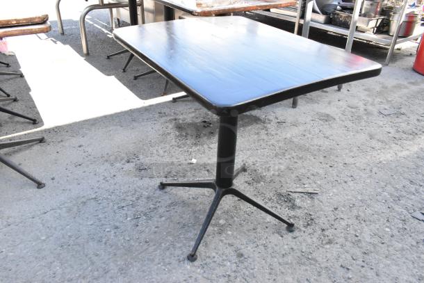 Set of 6 dining height tables with black square tops and metal bases. Used condition, ideal for restaurants.