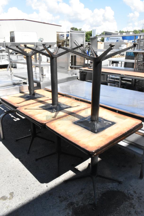 Six dining height tables on metal bases, wooden tops, used condition. Auction offers 6 tables per bid.