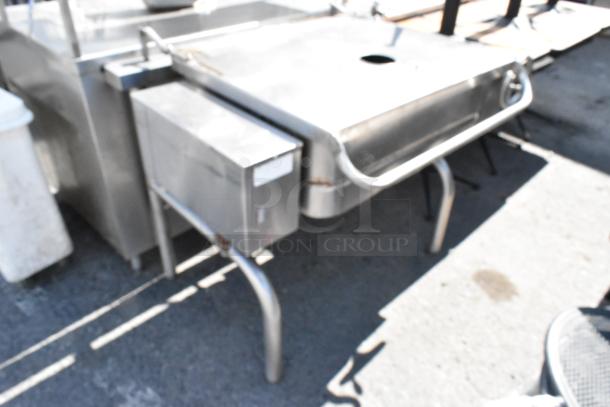 Stainless steel commercial manual tilt braising pan with handle, in used condition. Ideal for large-scale cooking.