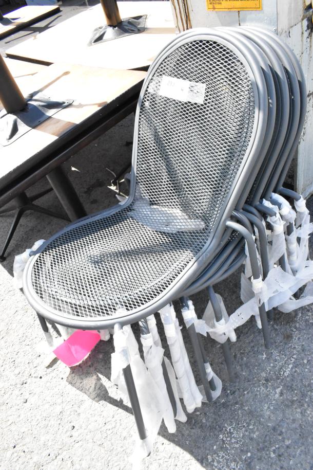 Set of 9 black metal mesh patio chairs in good condition, stacked neatly. Durable, weather-resistant design, ideal for outdoor use.