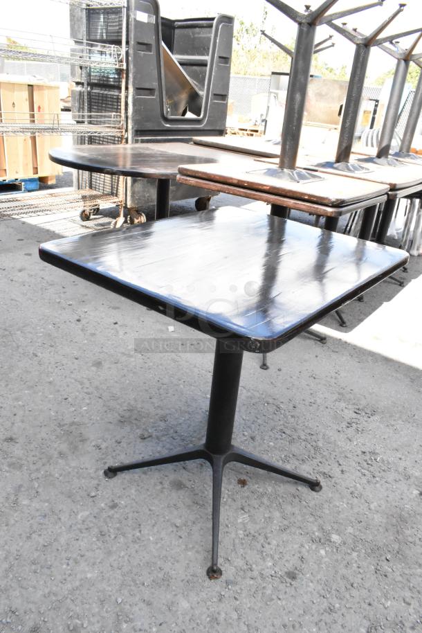 Nine dining height tables, square wood tops, metal X-bases, used condition, suitable for commercial settings.