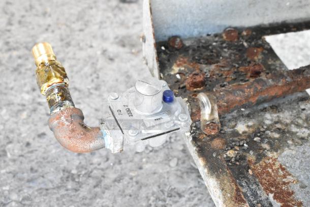 Old, rusted gas connection for commercial fryer, with visible wear. Features a label marked "RV47L" and "230073."