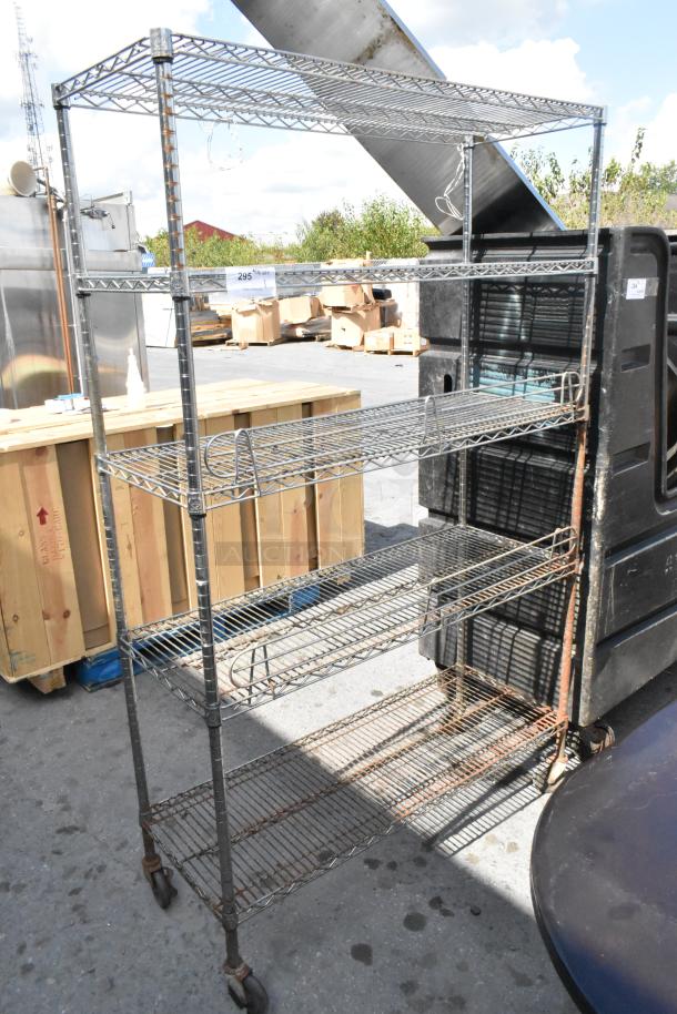 Chrome finish 5-tier wire shelving unit on commercial casters, used, with visible rust on lower tiers. Buyer must dismantle.
