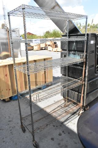 Chrome finish 5-tier wire shelving unit on commercial casters, used, with visible rust on lower tiers. Buyer must dismantle.
