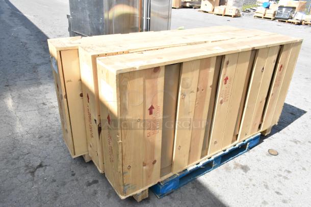 3 brand new doors in crates on a pallet, marked with "Glass Handle With Care"; ready for auction.