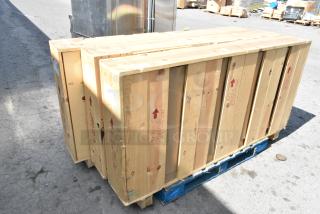 3 brand new doors in crates on a pallet, marked with "Glass Handle With Care"; ready for auction.