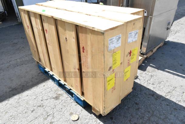 Three brand new doors in sealed wooden crates on a pallet, with shipping labels and handling instructions visible.