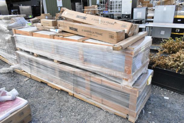 Pallet of 9 new scratch and dent items, including boxed patio umbrellas, labeled "Lancaster," plastic-wrapped, outdoors.