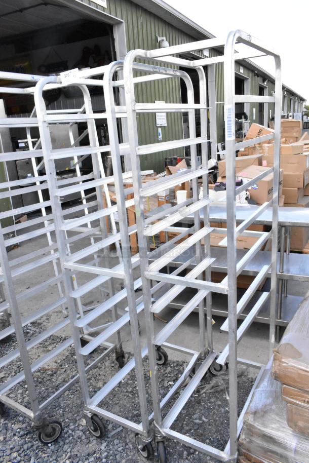 Two metal commercial pan transport racks on casters, used, featuring multiple shelves for storage, suitable for commercial kitchens.
