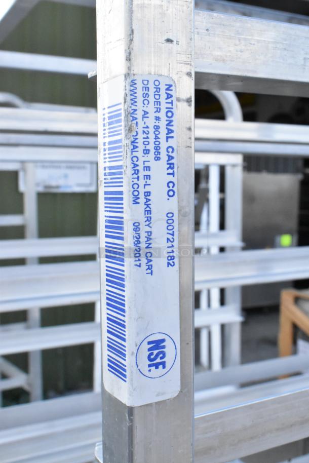 2 metal pan transport racks with commercial casters, by National Cart Co. Tags show order #8040968, NSF certified.