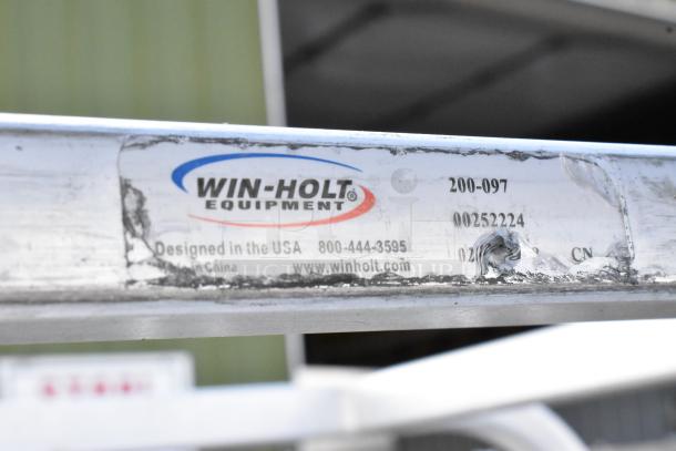 2 Win-Holt metal commercial pan transport racks on casters, model 200-097, designed in the USA. Some wear visible.