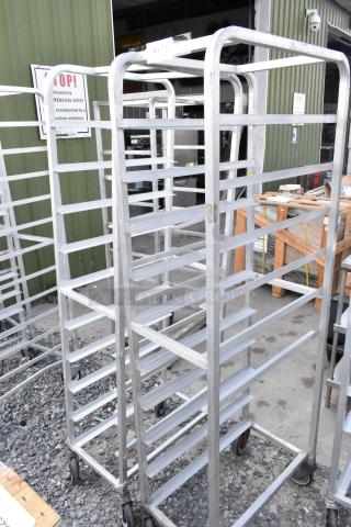 Two metal commercial pan transport racks on casters, one missing a caster. Durable, functional, ideal for kitchen use.